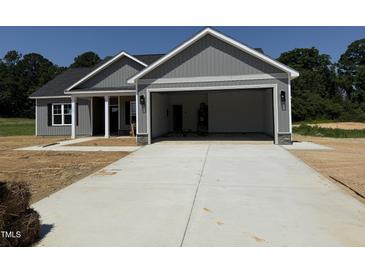 New home exterior showing large garage door and freshly poured driveway at 107 Tee Dr, Selma, NC 27576