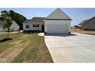 Charming single-story home with a concrete driveway and attached two car garage at 172 Royal Ave, Selma, NC 27576