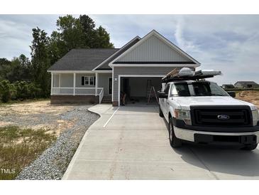 Charming single-story home featuring a covered porch, attached garage, and freshly poured concrete driveway at 192 Royal Ave, Selma, NC 27576