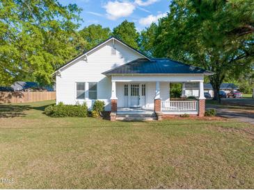 Charming white home with a covered front porch and mature landscaping at 206 Mansfield Dr, Broadway, NC 27505