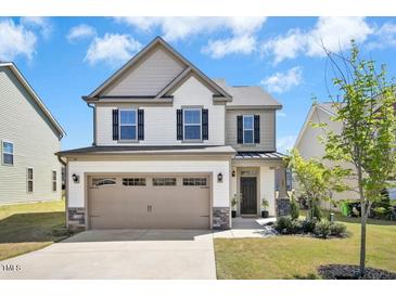 Charming two-story home with a two-car garage, well-manicured lawn, and neutral color scheme at 509 Rose Creek Ct, Zebulon, NC 27597