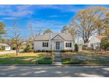 Charming home featuring a metal roof, landscaped yard, and inviting front entrance at 708 W Pope St, Dunn, NC 28334