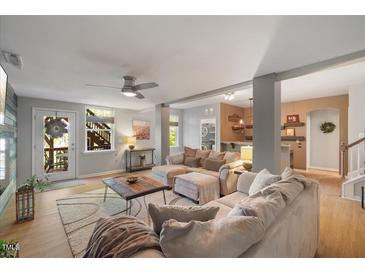 Bright and airy living room with plush seating, ceiling fan, and plenty of natural light at 725 Ancient Oaks Dr, Holly Springs, NC 27540