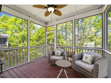 Cozy screened-in porch with two wicker chairs, a ceiling fan, and natural light at 725 Ancient Oaks Dr, Holly Springs, NC 27540