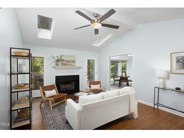 Bright living room with skylights, fireplace, and open floor plan to the dining room at 901 Clifford Dr, Durham, NC 27704