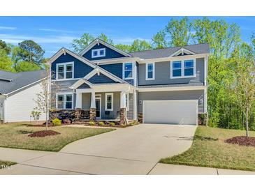 Two-story home featuring mixed siding, a two-car garage, and a meticulously landscaped front yard at 105 Scoville Rd, Garner, NC 27529