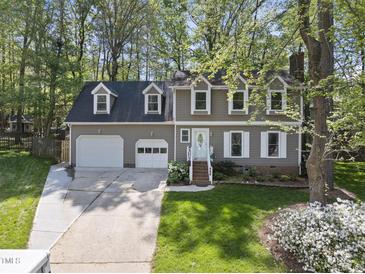 Traditional-style home features a two-car garage, dormer windows, and a well-manicured lawn at 108 Ridgepath Way, Cary, NC 27511