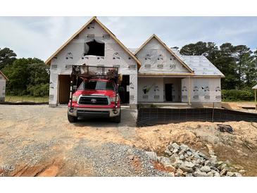 New home construction featuring a two car garage with a red truck parked in the driveway at 125 Tee Dr, Selma, NC 27576