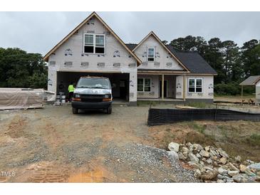 New construction home showing the front exterior with an attached garage in a partially developed lot at 125 Tee Dr, Selma, NC 27576