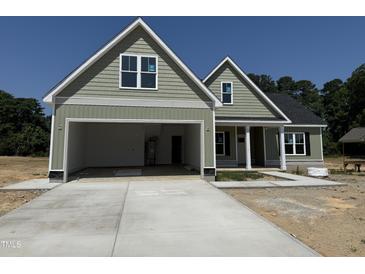 Two-story home featuring a two-car garage, shake siding and craftsman-style architectural details at 125 Tee Dr, Selma, NC 27576