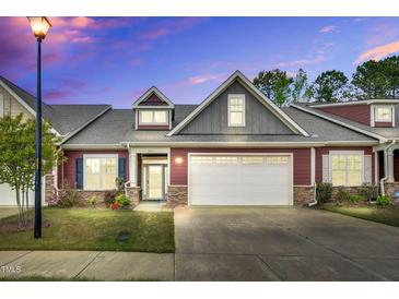 Charming exterior of home with two-car garage, stone accents and manicured lawn at 153 Telluride Trl, Garner, NC 27529