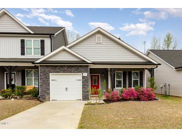 Charming home featuring gray siding, stone accents, a red front door, and a well-manicured lawn at 178 Cullen Ct, Clayton, NC 27520