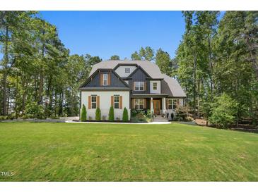 Stunning two-story home boasts a well-manicured lawn, mature trees, and inviting curb appeal at 188 E Antebellum Dr, Pittsboro, NC 27312