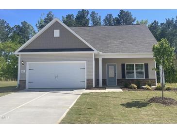 Charming single-Gathering home with a well-manicured lawn, attached garage, and beautiful landscaping at 201 Benton Dr, Oxford, NC 27565