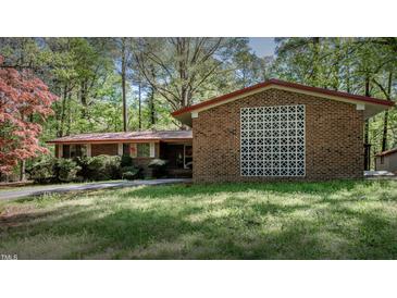 Charming brick home featuring mature landscaping and a classic mid-century modern design at 206 Rochelle Dr, Knightdale, NC 27545