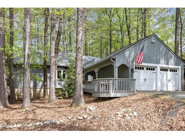 Charming home featuring a spacious two-car garage and welcoming front porch, nestled among beautiful trees at 227 Windlestraw, Pittsboro, NC 27312