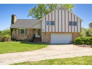 Charming two-story home featuring a brick facade and a spacious driveway leading to an attached garage at 2510 Poplar Creek Rd, Henderson, NC 27537