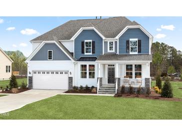 Charming two-story home featuring a mix of blue and white siding and a well-manicured lawn at 315 Adams Pointe Ct, Angier, NC 27501