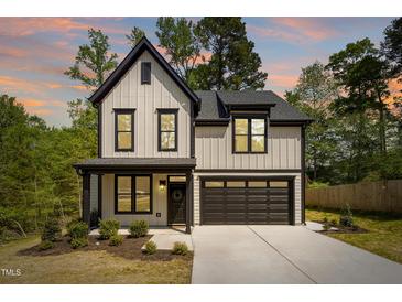 Two-story home featuring a modern farmhouse design with black trim and a two-car garage at 3221 Skycrest Dr, Raleigh, NC 27604