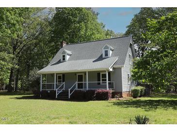 Charming home with a covered porch, black shutters, and well-manicured front yard at 5200 Lorbacher Rd, Apex, NC 27539