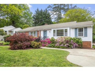 Charming single-story home with a beautifully landscaped front yard and inviting walkway leading to the front door at 611 Beaver Dam Rd, Raleigh, NC 27607