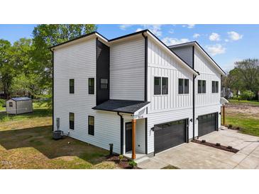 Modern two-story home with white siding, black trim, and a two-car garage offers contemporary curb appeal at 834 Day Ave, Burlington, NC 27217