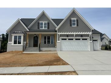 Beautiful craftsman home featuring a gray shingle exterior, white painted brick and a two-car garage at 921 Lily Claire Ln, Fuquay Varina, NC 27526