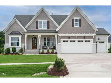 Charming two-story home with a beautifully landscaped front yard and a three-car garage at 921 Lily Claire Ln, Fuquay Varina, NC 27526