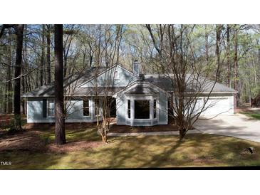 Charming single-story home nestled in a wooded lot with mature trees and a well-maintained lawn at 12124 Warwickshire Park, Raleigh, NC 27613