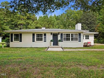 Charming exterior view of home featuring a manicured lawn, shuttered windows, and inviting front entrance at 1243 Nc 231, Wendell, NC 27591