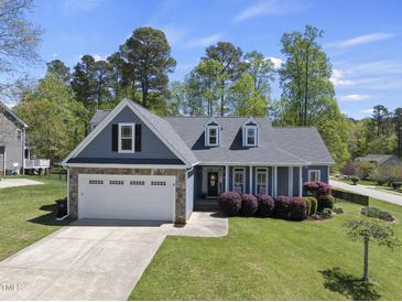 Charming single-Gathering home with a well-maintained lawn, stone accents, and attached two-car garage at 129 Camille Cir, Youngsville, NC 27596
