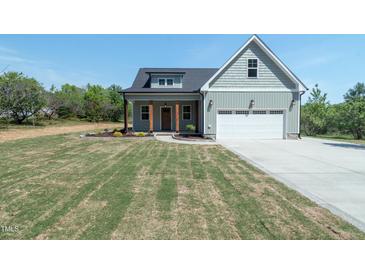 Charming home featuring a two-car garage and well-manicured lawn at 1394 Delma Grimes Rd, Coats, NC 27521