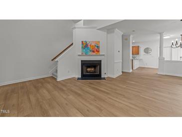 Bright living room features hardwood floors, a fireplace, and staircase, creating a cozy and inviting atmosphere at 1640 Legendary Ln, Morrisville, NC 27560