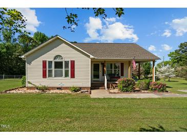Charming home featuring tidy landscaping, red shutters, and a cozy front porch at 20 Sanders Rd, Benson, NC 27504