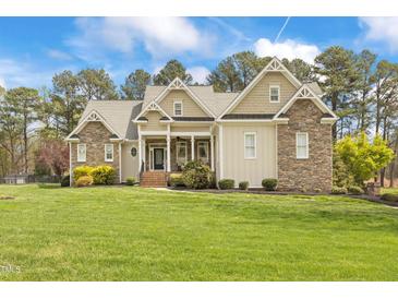 Stunning stone and siding home featuring a large manicured lawn and classic architectural details at 2000 Silverleaf Dr, Youngsville, NC 27596