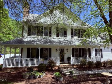 Charming two-story home with a spacious front porch, black shutters and landscaped front yard at 2385 Olde Spring Ct, Graham, NC 27253