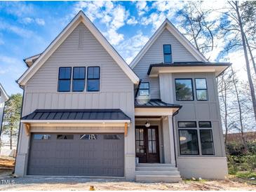 Charming two-story home with a gray exterior, black window frames, and a two car garage at 3000 Eden Harbor Ct, Raleigh, NC 27613