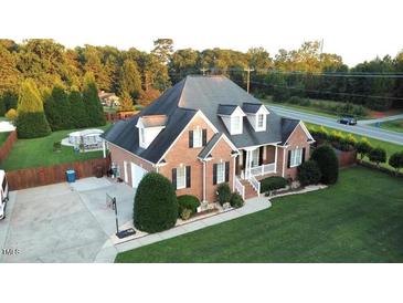 Charming brick home featuring manicured lawn, driveway, attached garage, and attractive landscaping at 3098 Creek Point Rd, Graham, NC 27253