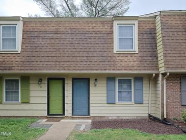 Charming townhouse exterior featuring muted siding, colorful doors and shutters, and a shingle roof at 4816 Blue Bird Ct # B, Raleigh, NC 27606