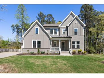 Charming two-story home boasts a welcoming front porch and well-manicured lawn at 50 Gadwall Ct, Zebulon, NC 27597