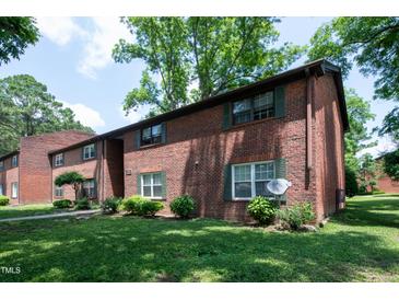 Brick apartment building with green shutters, well-kept landscaping, and mature trees at 5804 Falls Of Neuse Rd # E, Raleigh, NC 27609