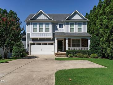 Charming two-story home with a two-car garage, covered porch, and well-maintained landscaping at 65 N Wilders Ridge Way, Clayton, NC 27527