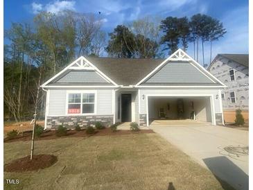 Charming single-story home featuring a two-car garage, landscaping, and inviting curb appeal at 75 Bald Cypress Ln, Youngsville, NC 27596