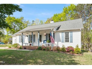 Charming one-story home with a welcoming front porch and an American flag, perfect for suburban living at 807 Clean View Ct, Fuquay Varina, NC 27526