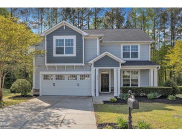 Charming two-story home featuring a two-car garage, well-maintained lawn, and inviting front porch at 858 Lake Artesia Ln, Fuquay Varina, NC 27526