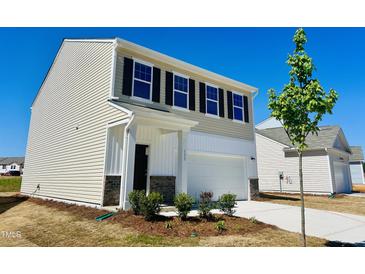 New construction home featuring a two-car garage, black shutters, manicured yard, and neutral color palette at 133 N Keatts Winner Ct, Wilson's Mills, NC 27520