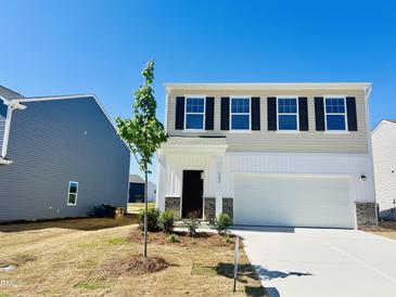 Two-story home with a white garage door, stylish black shutters, and fresh landscaping at 133 N Keatts Winner Ct, Wilson's Mills, NC 27520