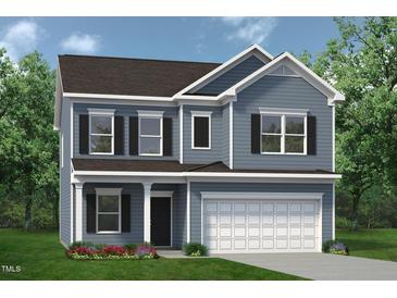 Charming two-story home featuring blue siding, black shutters, and a well-manicured lawn with colorful flower beds at 143 Mildred Place, Broadway, NC 27505