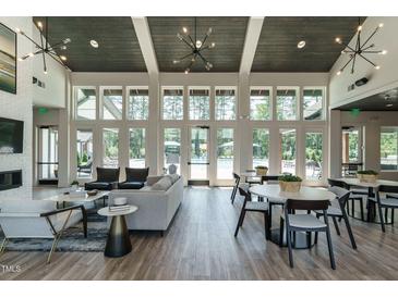 Bright resident lounge featuring modern furniture, fireplace, high ceilings, and view of pool at 1636 Raven Falls Dr, Wendell, NC 27591