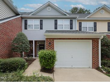 Charming two-story townhome featuring an attached one-car garage and well-manicured landscaping at 2067 White Pond Ct, Apex, NC 27523